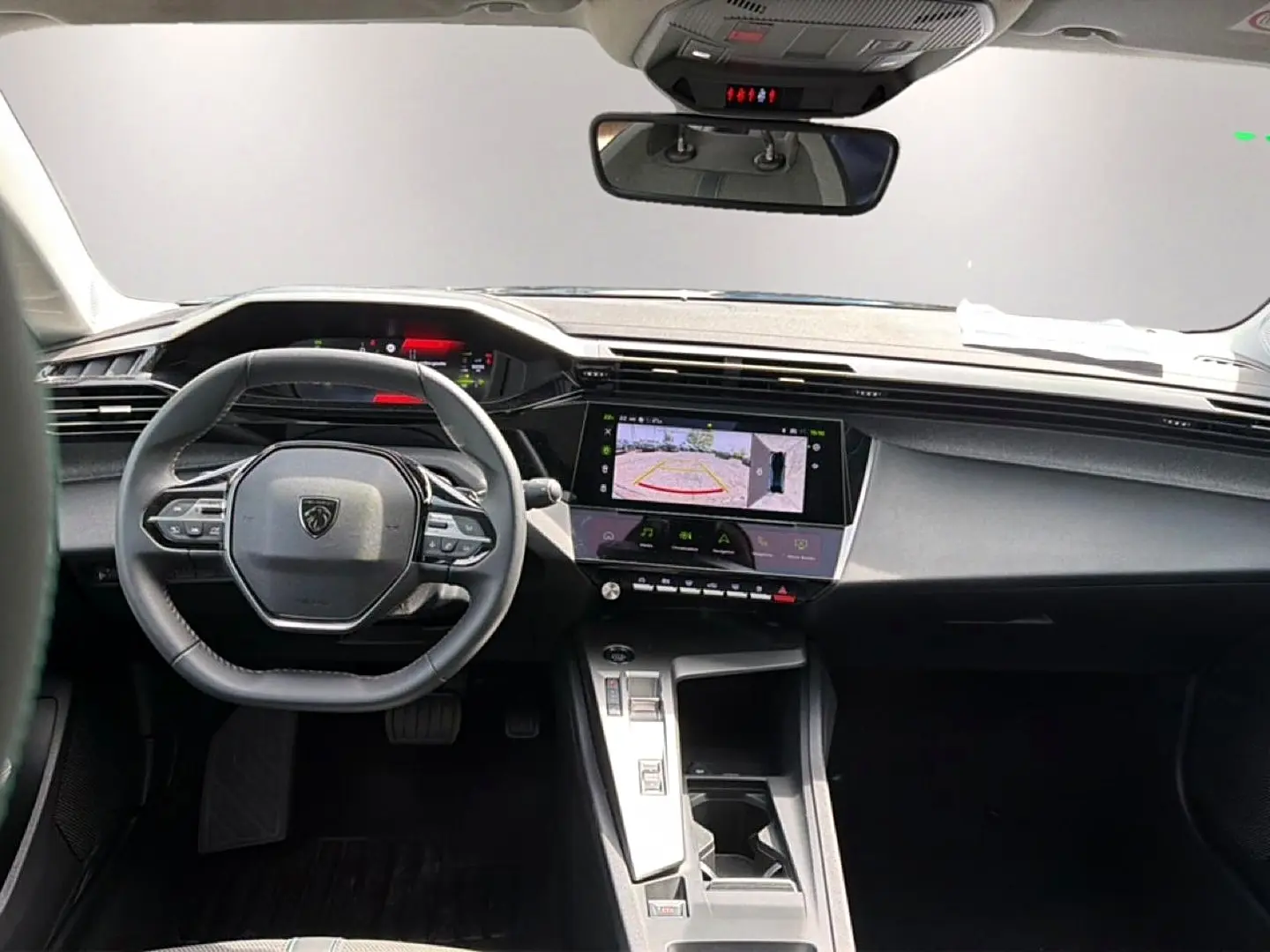 Vue intérieure avant de la Peugeot 408 Hybrid noire, avec volant cuir, écran tactile affichant la caméra de recul.