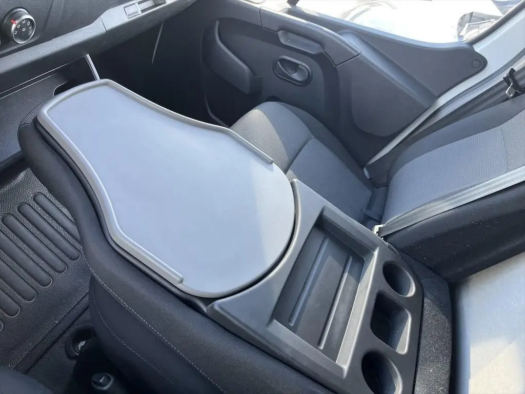Vue intérieure côté passager du Renault Master blanc 2021, avec tablette rabattable et porte-gobelets intégrés.
