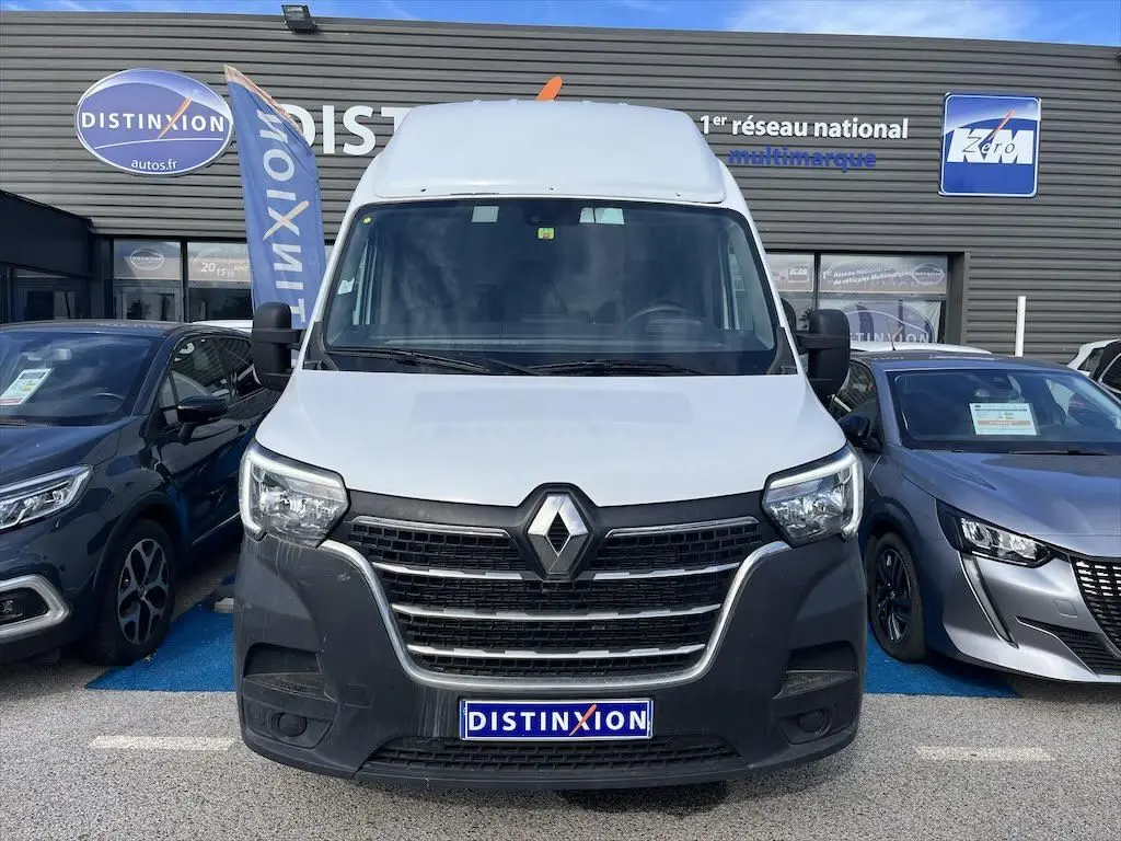 Vue frontale d'un Renault Master blanc stationné devant un concessionnaire avec logo Distinxion visible.