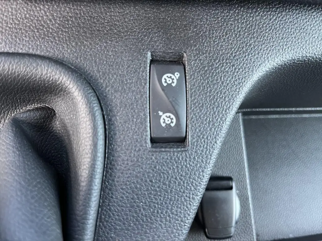 Gros plan sur le bouton de régulateur de vitesse dans l'habitacle noir du Renault Master blanc 2021.