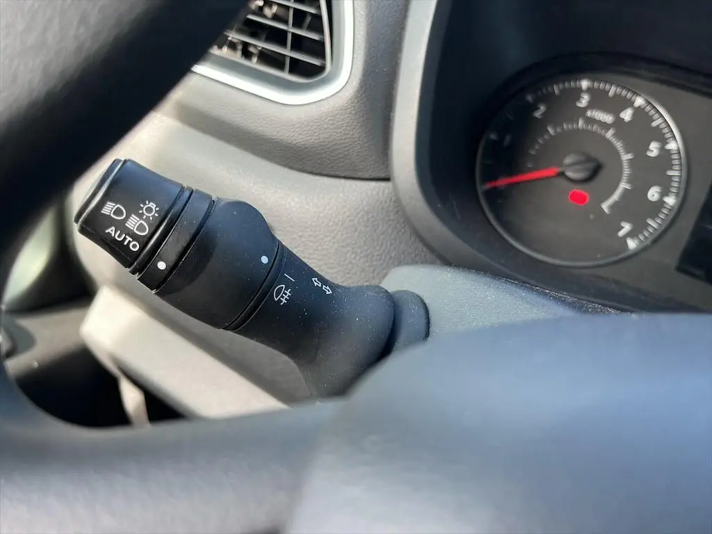 Gros plan sur la commande des phares et clignotants dans l'habitacle du Renault Master blanc, tableau de bord en arrière-plan.