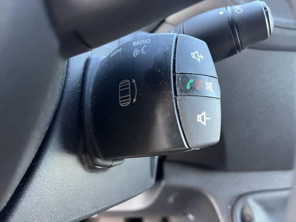 Gros plan sur la commande au volant du Renault Master blanc 2021, boutons pour volume et appels téléphoniques.