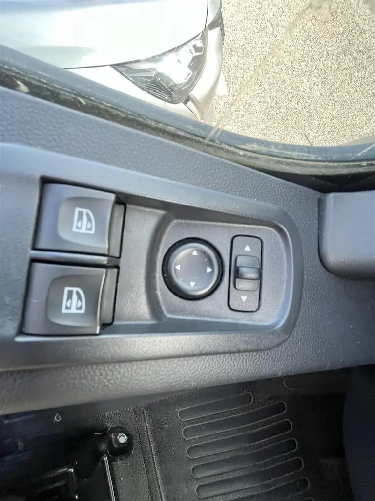 Gros plan sur les commandes de réglage des rétroviseurs et vitres côté conducteur du Renault Master blanc 2021.