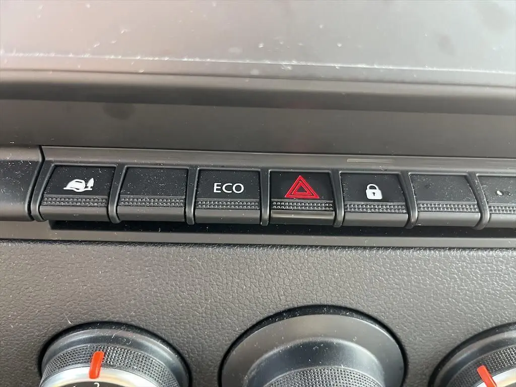 Gros plan sur les boutons de commande du tableau de bord du Renault Master blanc, avec bouton ECO et alerte triangle rouge.