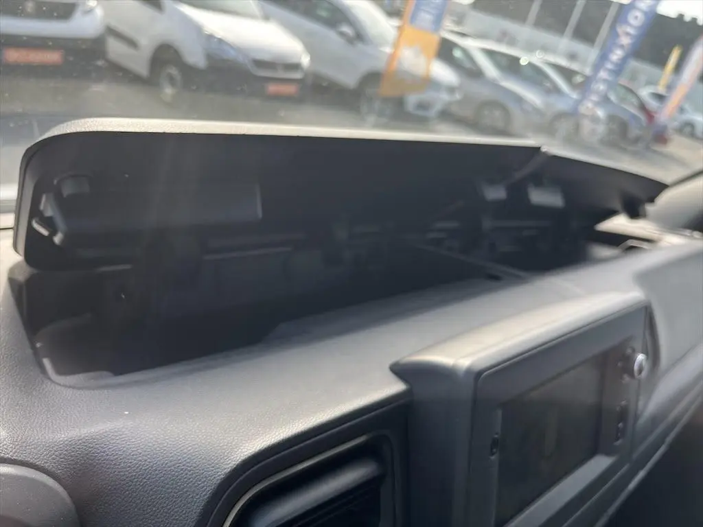 Vue rapprochée du compartiment de rangement ouvert sur le tableau de bord du Renault Master blanc de 2021.