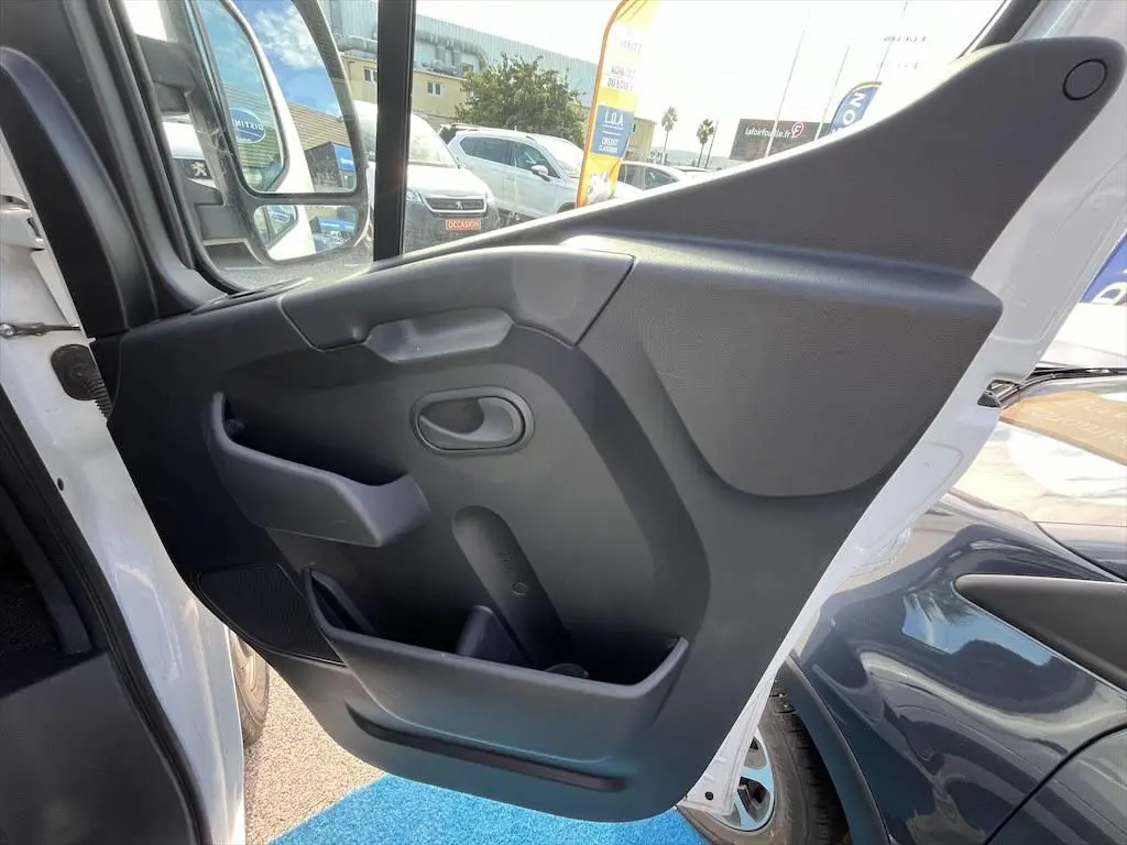 Vue rapprochée de la porte avant gauche blanche du Renault Master 2021, montrant la garniture intérieure noire.