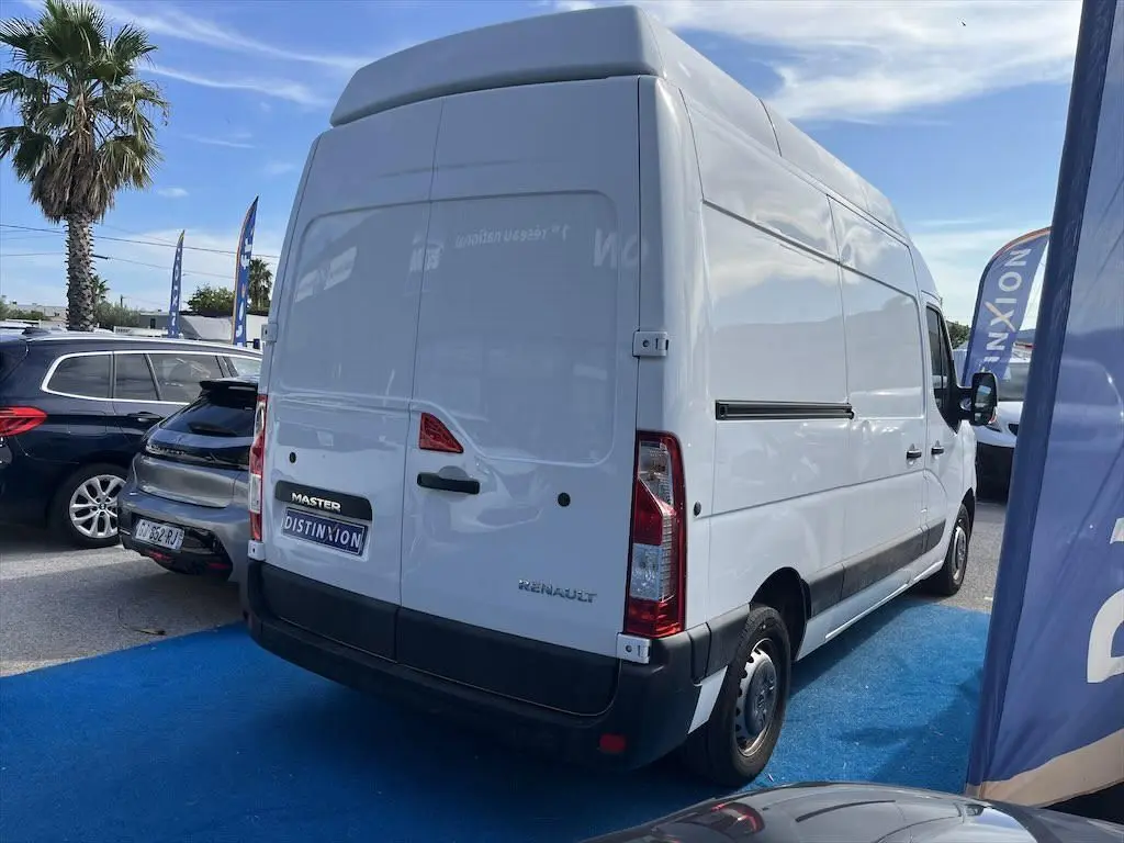 Renault Master blanc, vue 3/4 arrière droit, fourgon utilitaire avec toit surélevé sur parking extérieur.