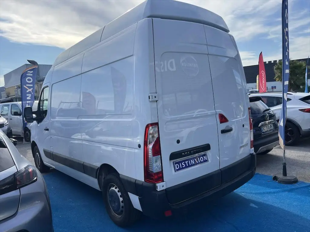 Renault Master blanc en vue 3/4 arrière droit sur un parking avec logo Distinxion sur la porte arrière.