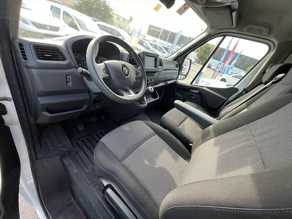 Intérieur côté conducteur du Renault Master blanc 2021, montrant le tableau de bord et les sièges en tissu gris.