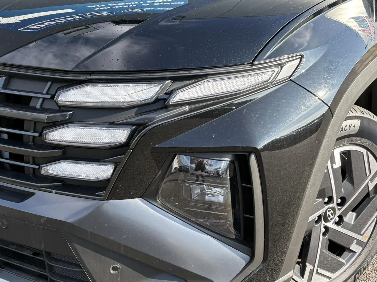 Gros plan sur l'avant droit du Hyundai Tucson Abyss Black 2025, mettant en valeur ses feux LED et jante alliage.