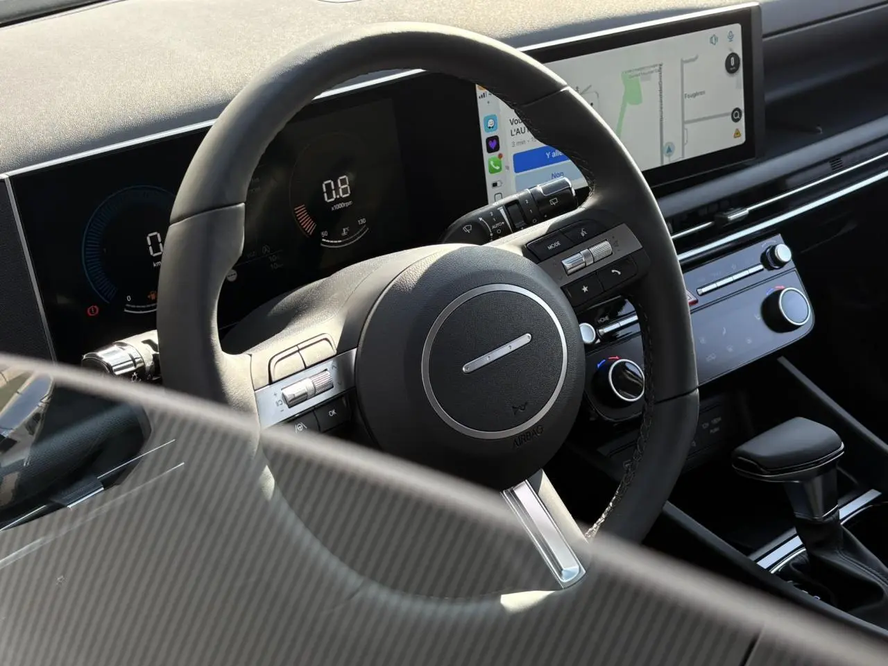 Intérieur du Hyundai Tucson 2025 vu côté conducteur, volant cuir avec commandes et écran tactile central.