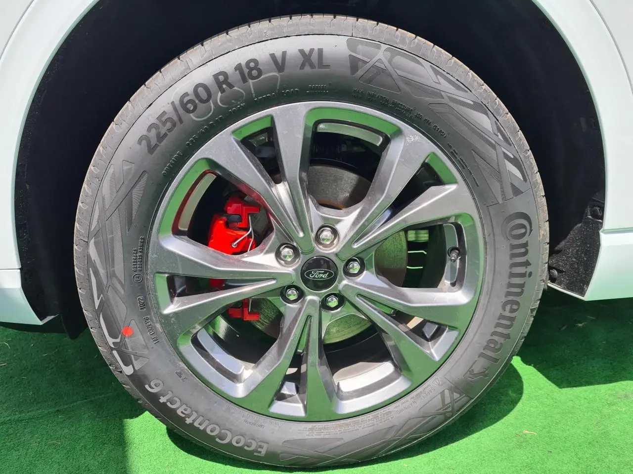 Gros plan sur la roue avant droite du Ford Kuga blanc glacier avec jante alliage 18 pouces et étrier de frein rouge.