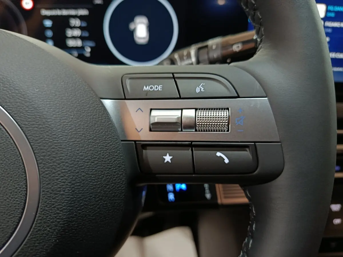 Gros plan sur les commandes multifonctions à droite du volant cuir noir du Hyundai Tucson gris foncé 2025.