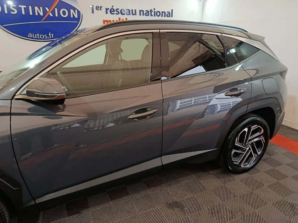Vue de profil côté gauche du Hyundai Tucson 1.6 Hybrid 239 Creative Auto gris foncé avec jantes modernes en alliage.
