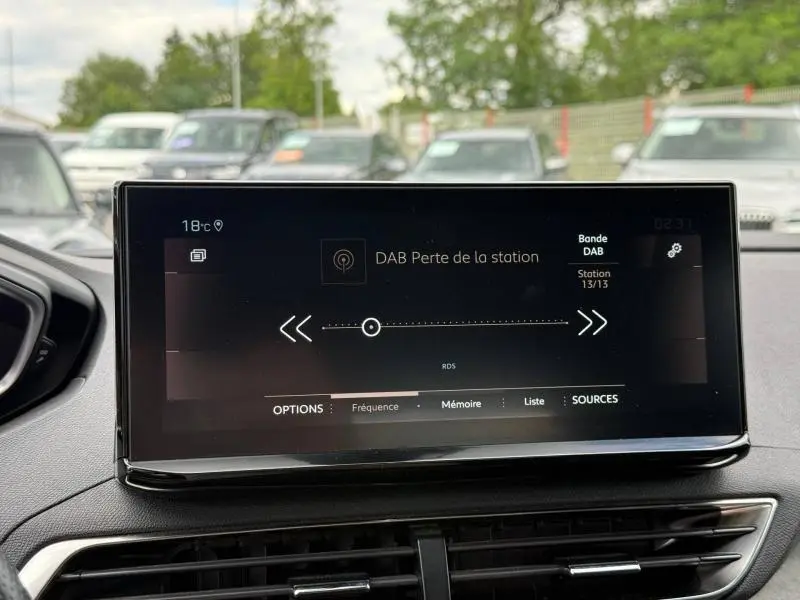 Écran tactile central du Peugeot 3008 gris Platinium, affichant la radio DAB en intérieur jour.