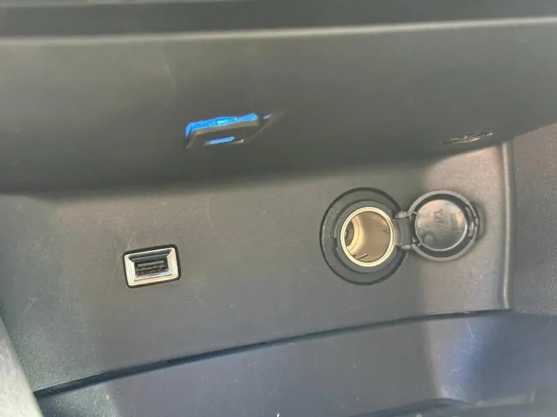 Prise USB et allume-cigare ouverts dans la console centrale du Peugeot 3008 Gris Platinium 2024.