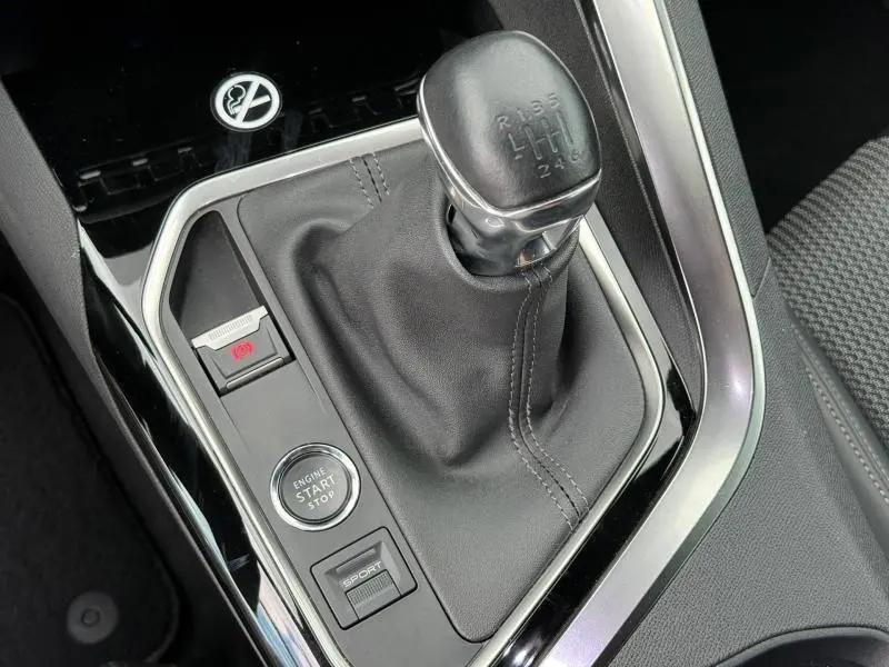 Vue rapprochée du levier de vitesses manuel noir et des commandes sport et démarrage du Peugeot 3008 Gris Platinium 2024.