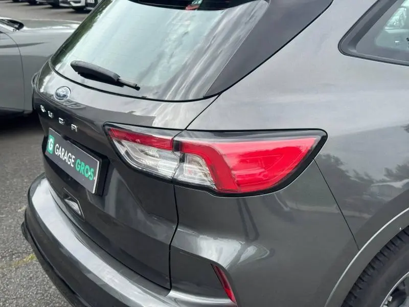 Vue 3/4 arrière droite d'un Ford Kuga gris Solar métallisé avec feux arrière LED et hayon fermé.