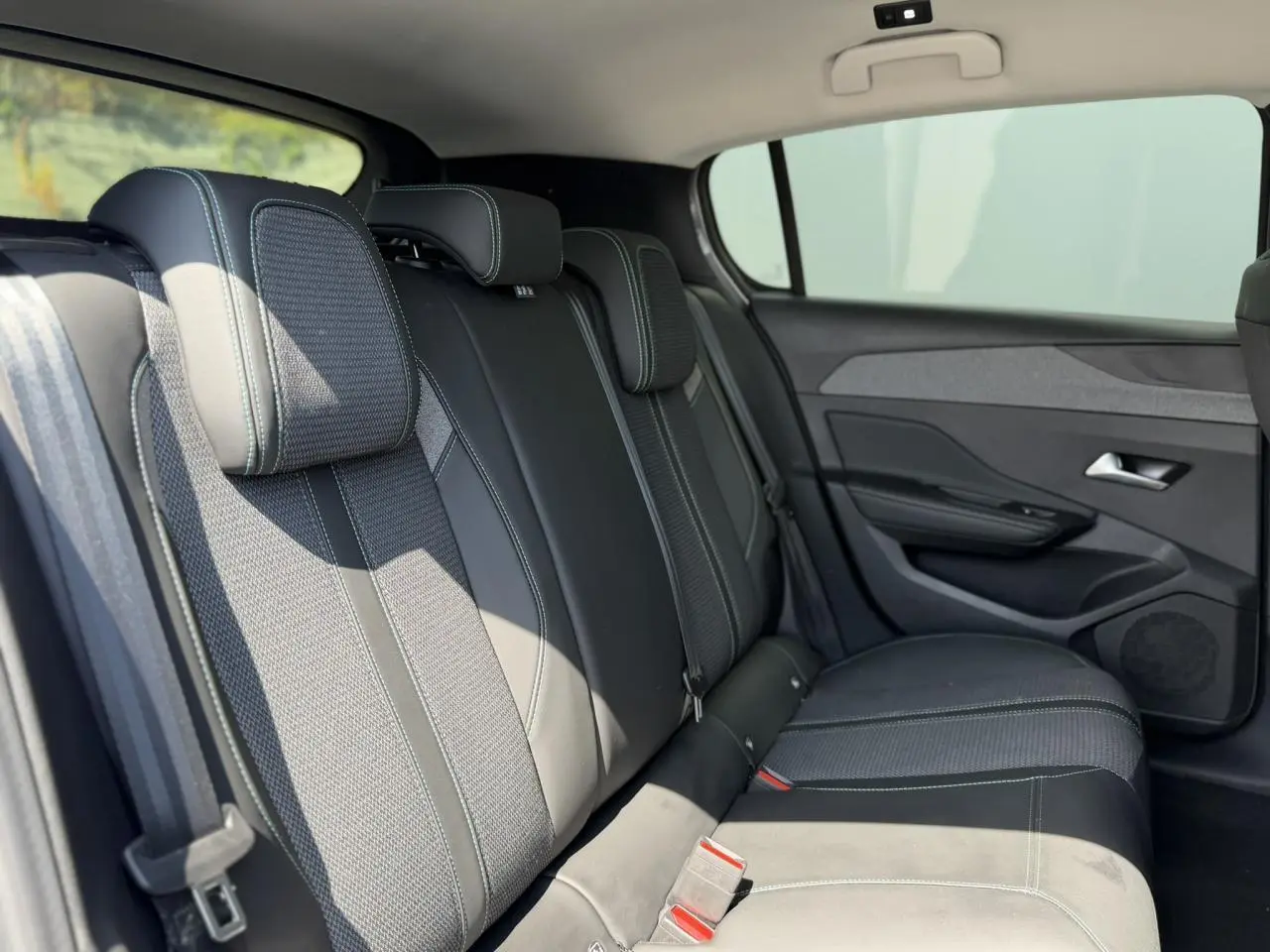 Vue intérieure côté droit des sièges arrière en tissu et cuir noir avec surpiqûres contrastantes dans une Peugeot 308 2025.