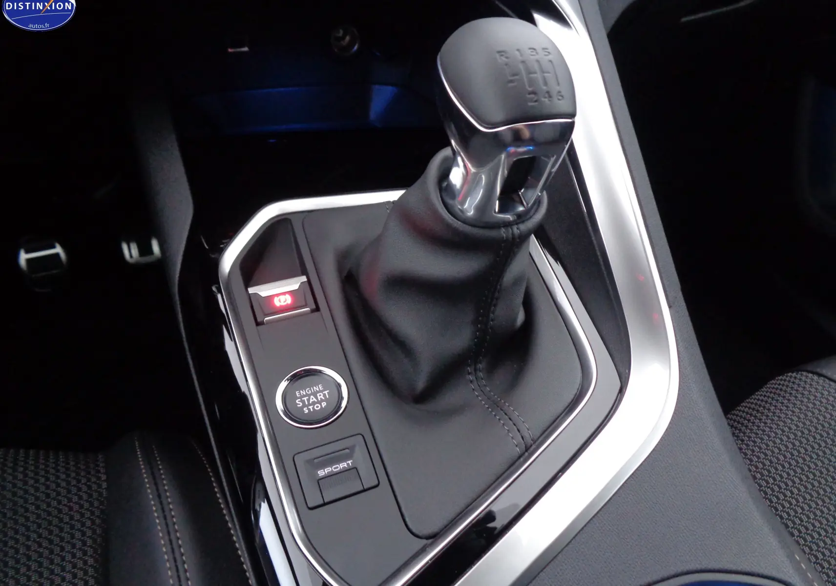 Gros plan sur le levier de vitesse manuel et les boutons start/stop et sport dans l'habitacle du Peugeot 3008 2023.