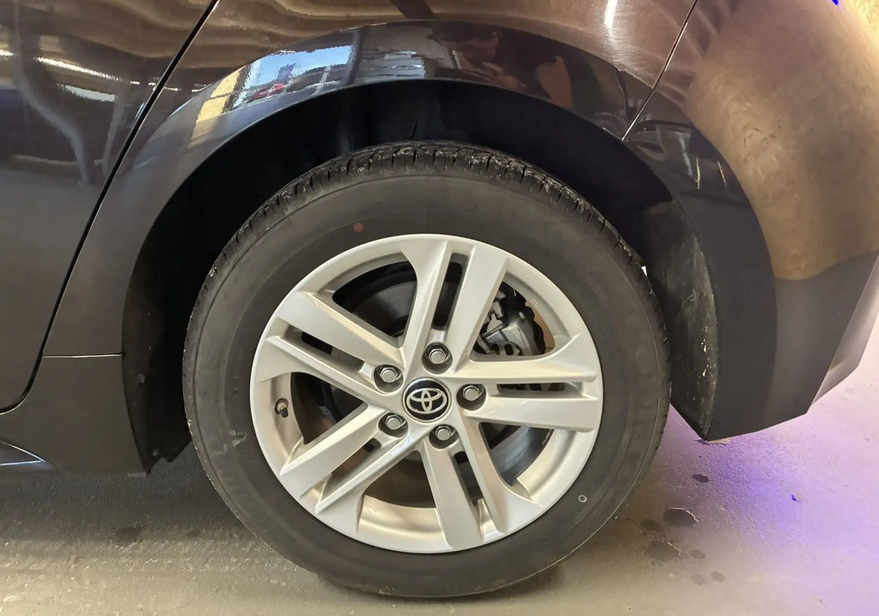 Gros plan sur la jante alu argentée et le passage de roue noir d'une Toyota Corolla 1.8 122 Dynamic 2020.