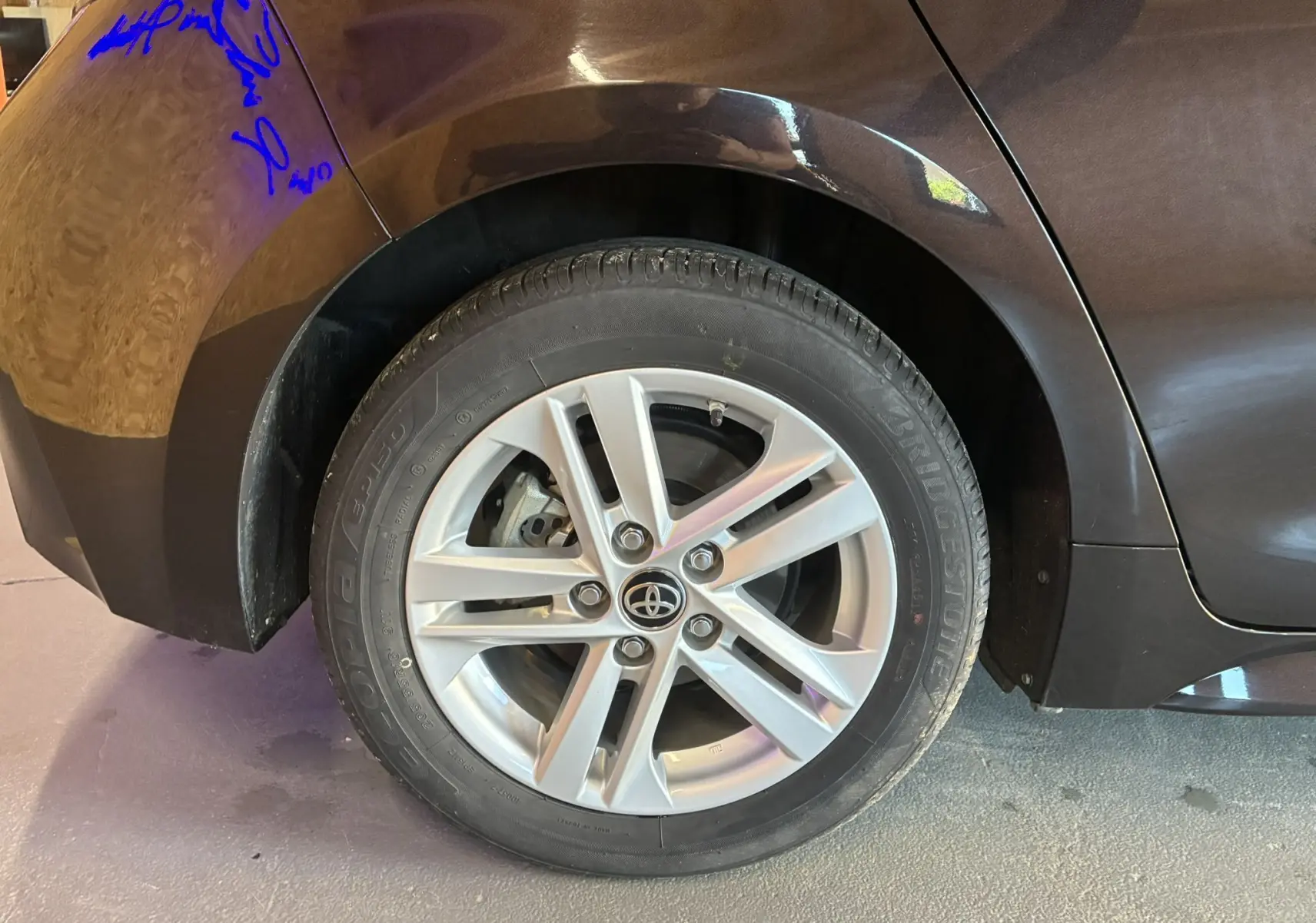 Gros plan sur la jante alu avant droite d'une Toyota Corolla noire 2020, soulignant le design moderne du pneu Bridgestone.