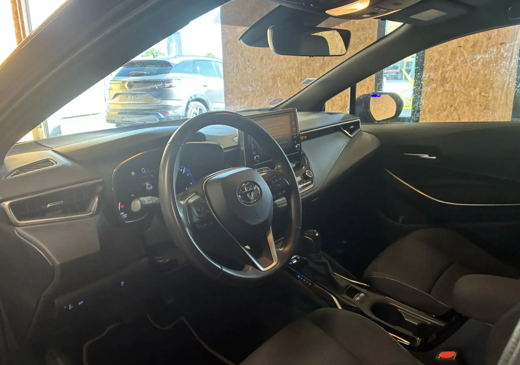 Intérieur noir de la Toyota Corolla 1.8 122 Dynamic 2020, vue côté conducteur avec volant multifonctions et écran tactile central.