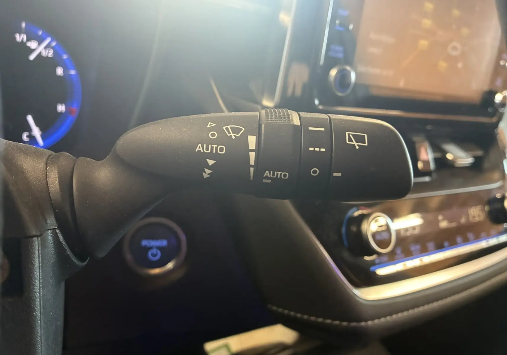 Gros plan sur la commande d’essuie-glaces automatique dans l’habitacle noir d’une Toyota Corolla 1.8 122 Dynamic 2020.