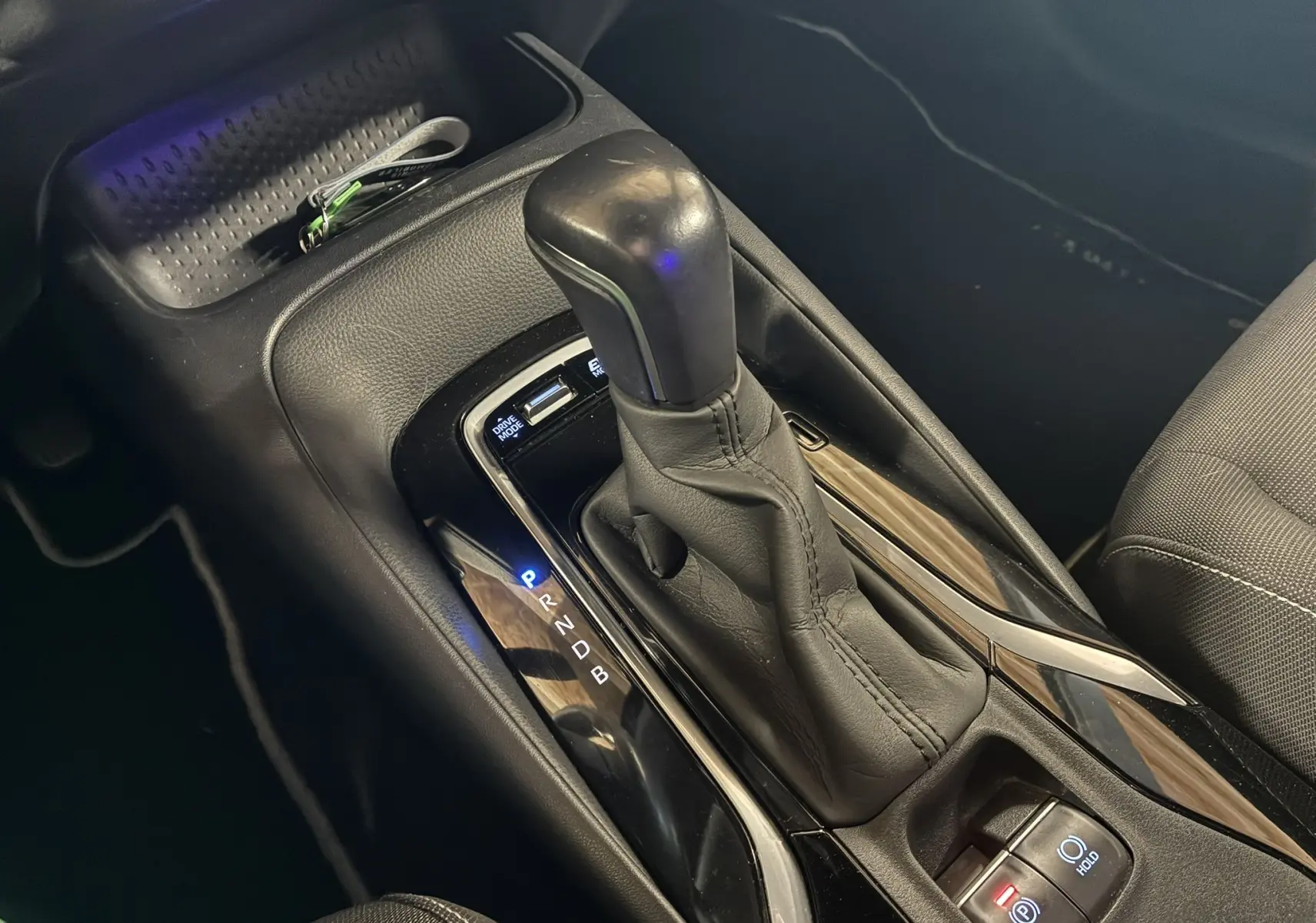 Le levier de vitesses automatique en cuir noir de la Toyota Corolla 1.8 122 Dynamic vue en gros plan côté console centrale.