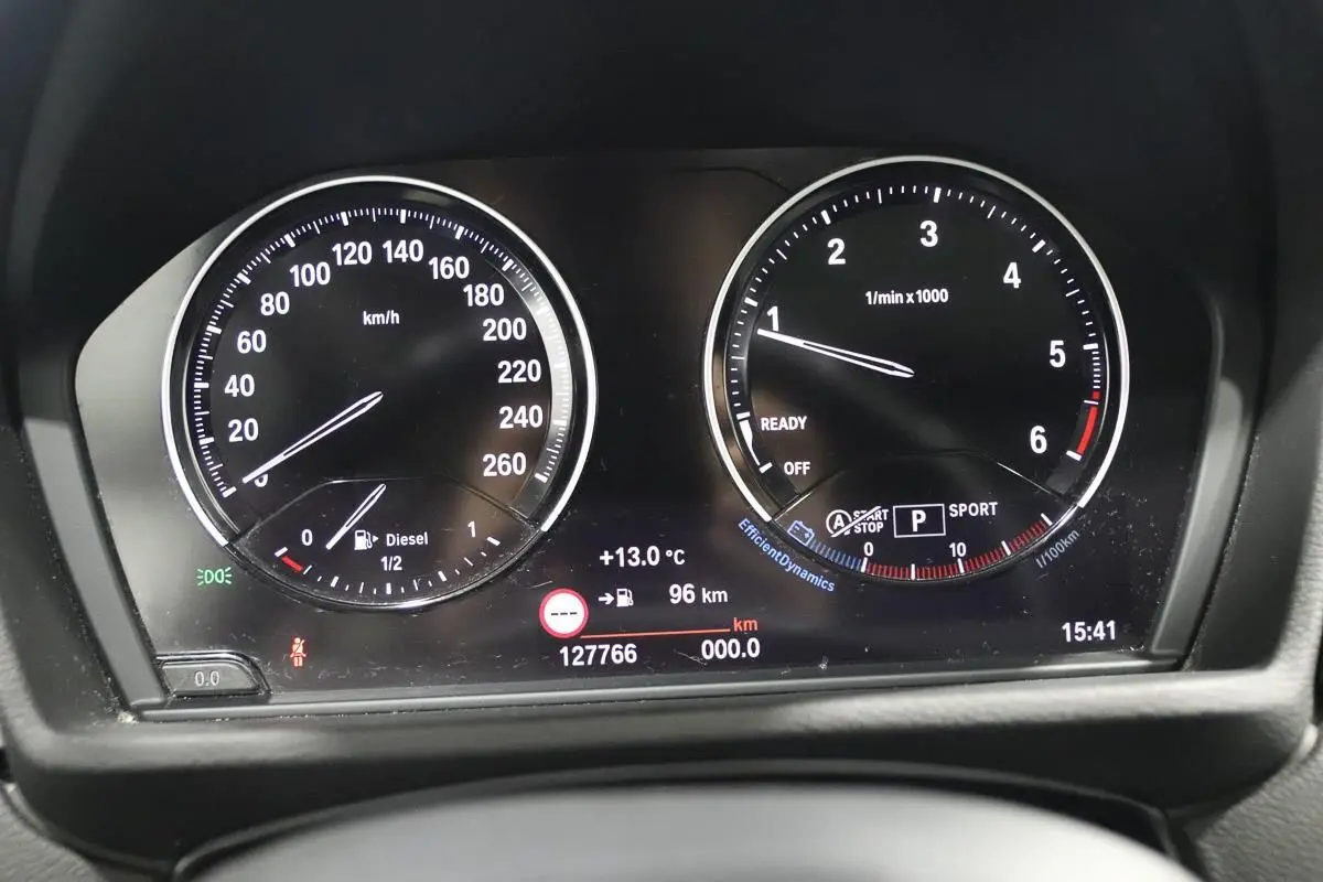 Vue rapprochée du tableau de bord numérique du BMW X1 sDrive 18D, affichant vitesse, régime et informations de conduite.