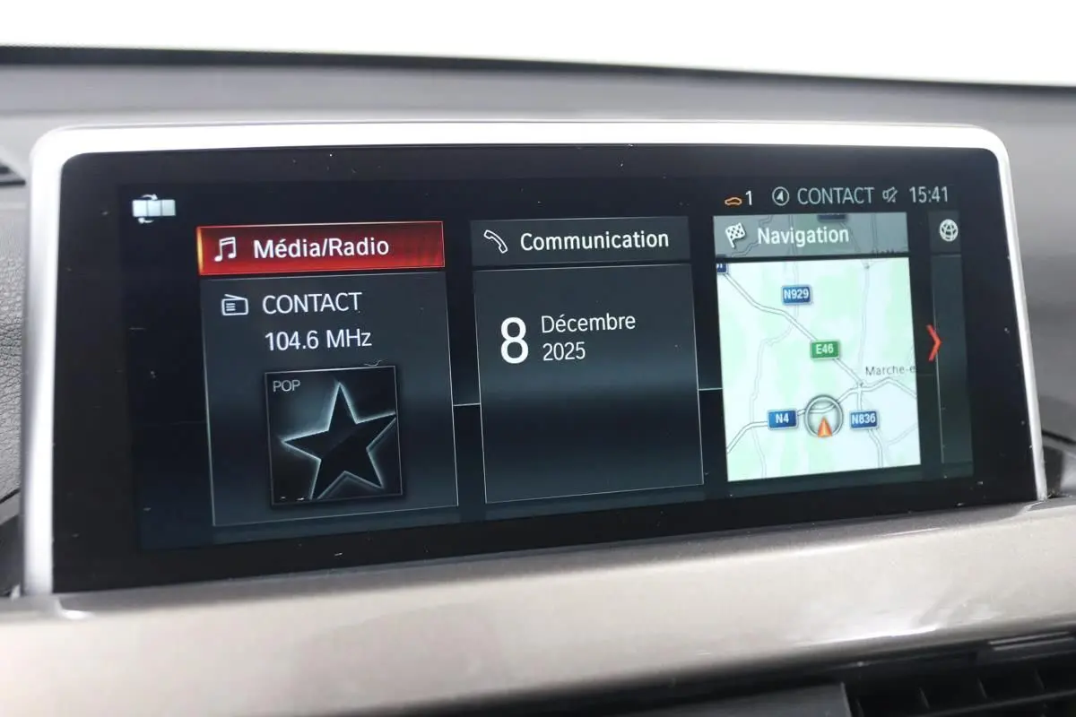 Écran central de la BMW X1 sDRIVE 18D 2019 montrant l'interface multimédia avec navigation et radio, vue intérieure.