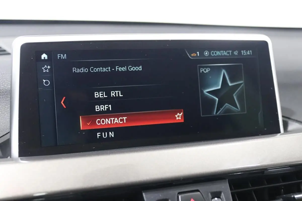 Écran central de la BMW X1 sDRIVE 18D 2019 affichant la sélection radio sur fond noir avec interface moderne.