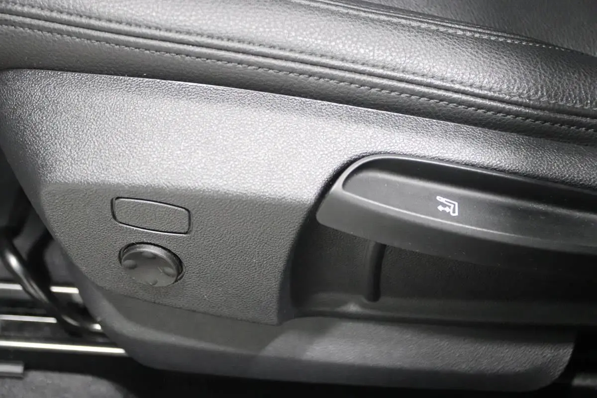 Détail des commandes de réglage du siège en cuir noir dans une BMW X1 sDrive 18D 2019.