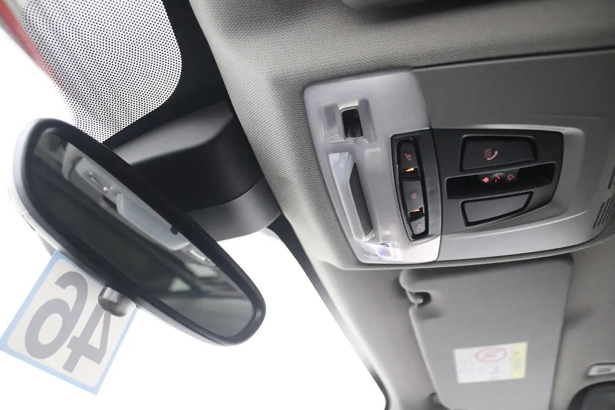 Vue intérieure du plafond avec rétroviseur et commandes d'éclairage du toit ouvrant d'une BMW X1 argentée 2019.