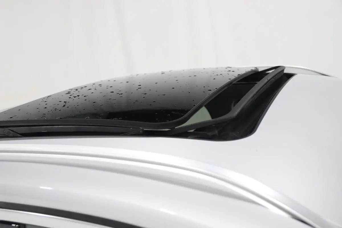 Toit ouvrant partiellement ouvert sur BMW X1 sDrive 18D argent métallisé, vue rapprochée du toit côté gauche.