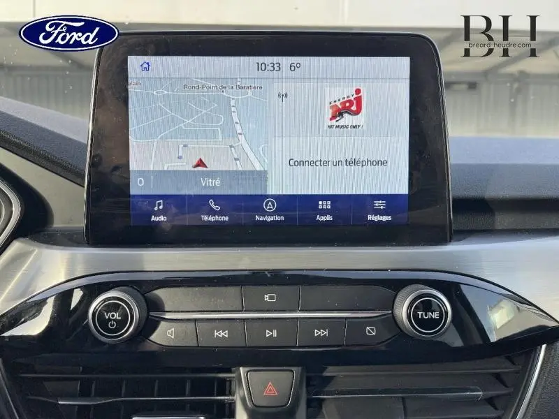 Vue rapprochée de l’écran tactile central et de la console noire du tableau de bord du Ford Kuga 2020.