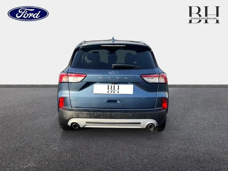 Vue arrière d'un Ford Kuga 2.0 EcoBlue 190ch Titanium bleu azur métallisé avec double sortie d'échappement et vitres arrière surteintées.