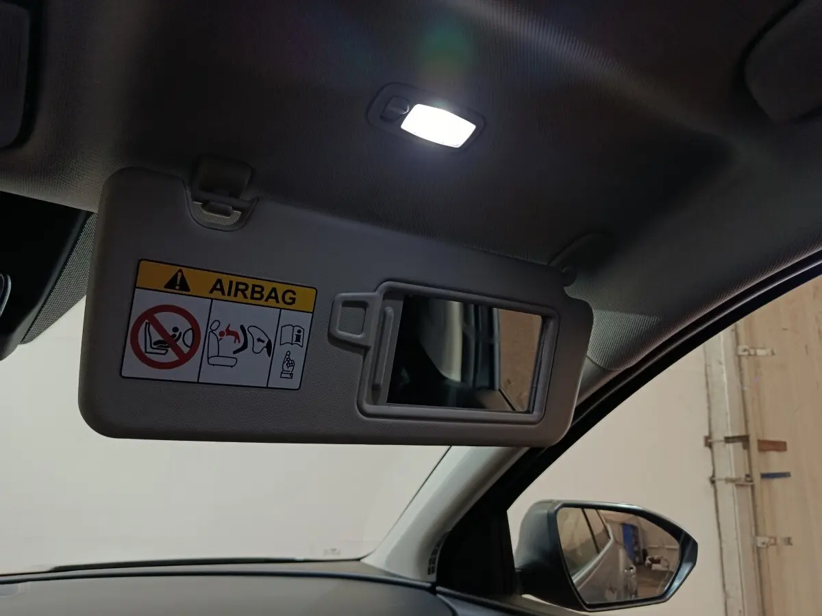Détail du pare-soleil côté conducteur avec miroir et étiquette airbag dans un Hyundai Tucson gris clair 2025.