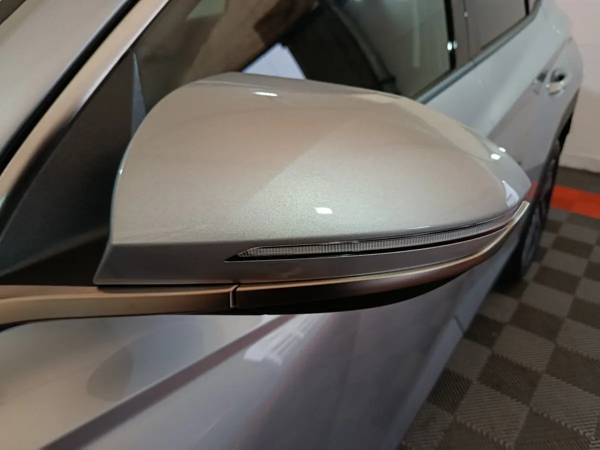 Gros plan sur le rétroviseur droit gris clair du Hyundai Tucson 2025, avec clignotant intégré, vue latérale.