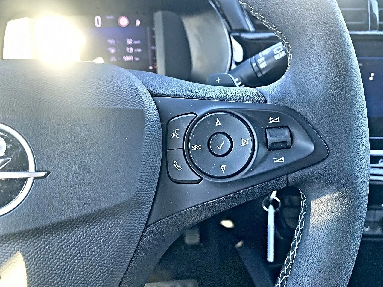 Gros plan sur le volant noir multifonction de l’Opel Corsa 2025 avec commandes audio et logo central visible.
