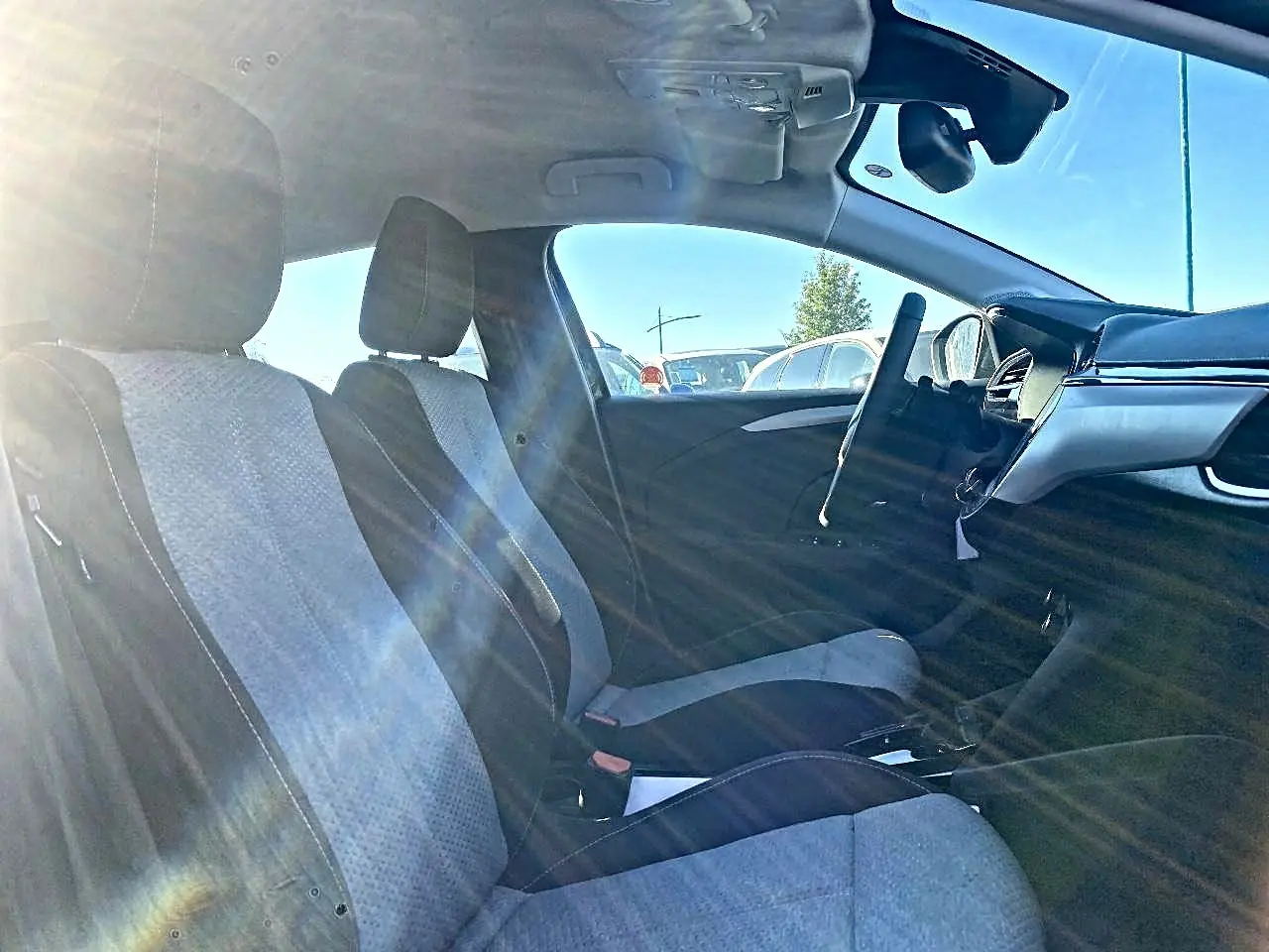 Vue intérieure côté droit de l’Opel Corsa 2025, sièges tissu noir et gris, volant multifonction et tableau de bord moderne.