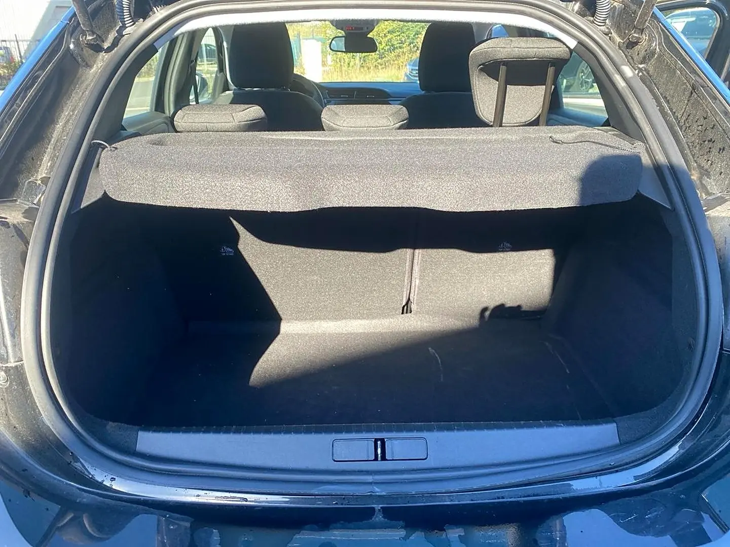 Coffre ouvert vu de l'arrière d'une Opel Corsa noire 2025, avec cache-bagages et banquette arrière visible.