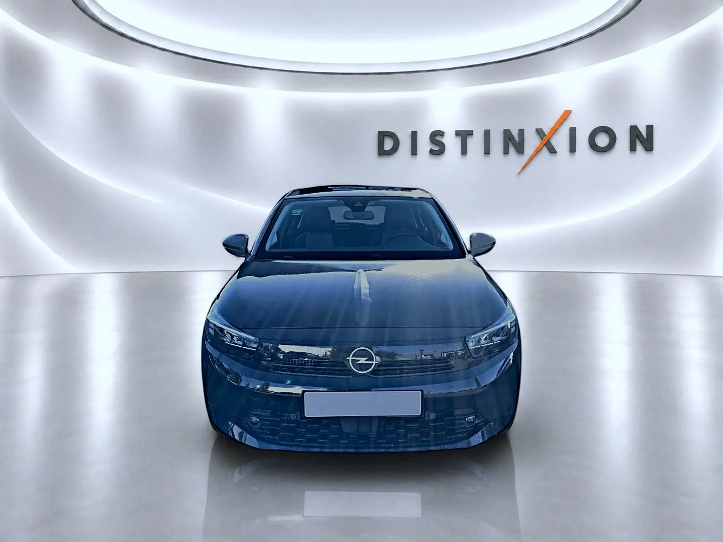 Opel Corsa noire vue de face dans un showroom lumineux avec logo Distinxion en arrière-plan.