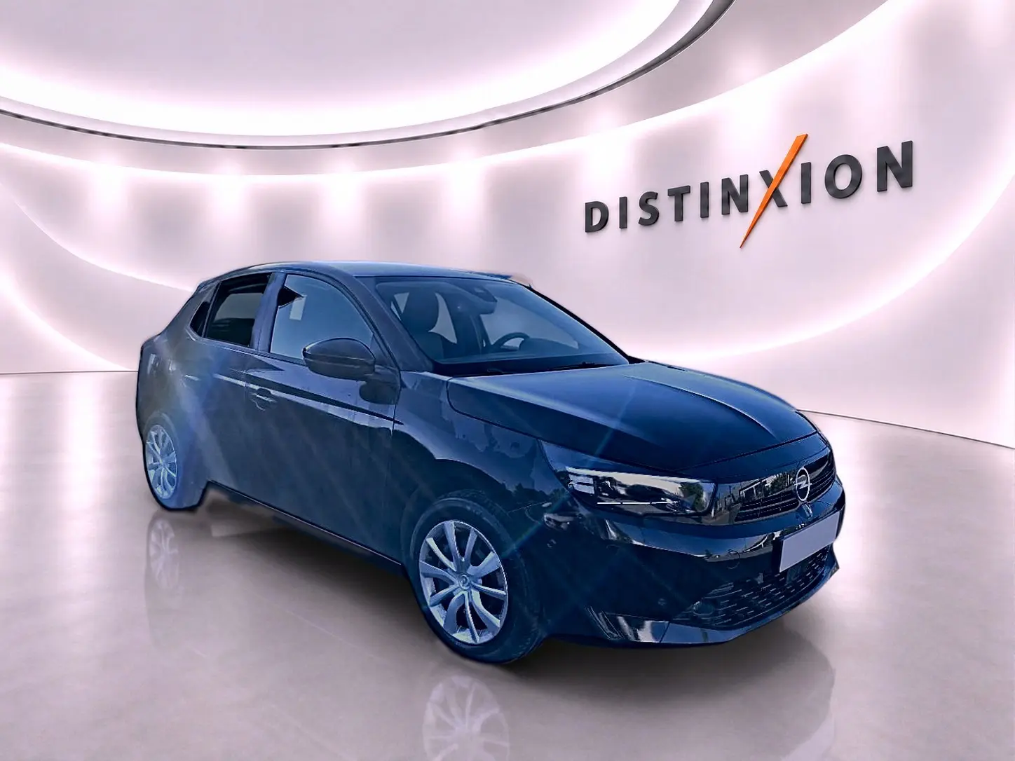 Opel Corsa noire vue en 3/4 avant droit dans un showroom lumineux avec jantes argentées et calandre noire.