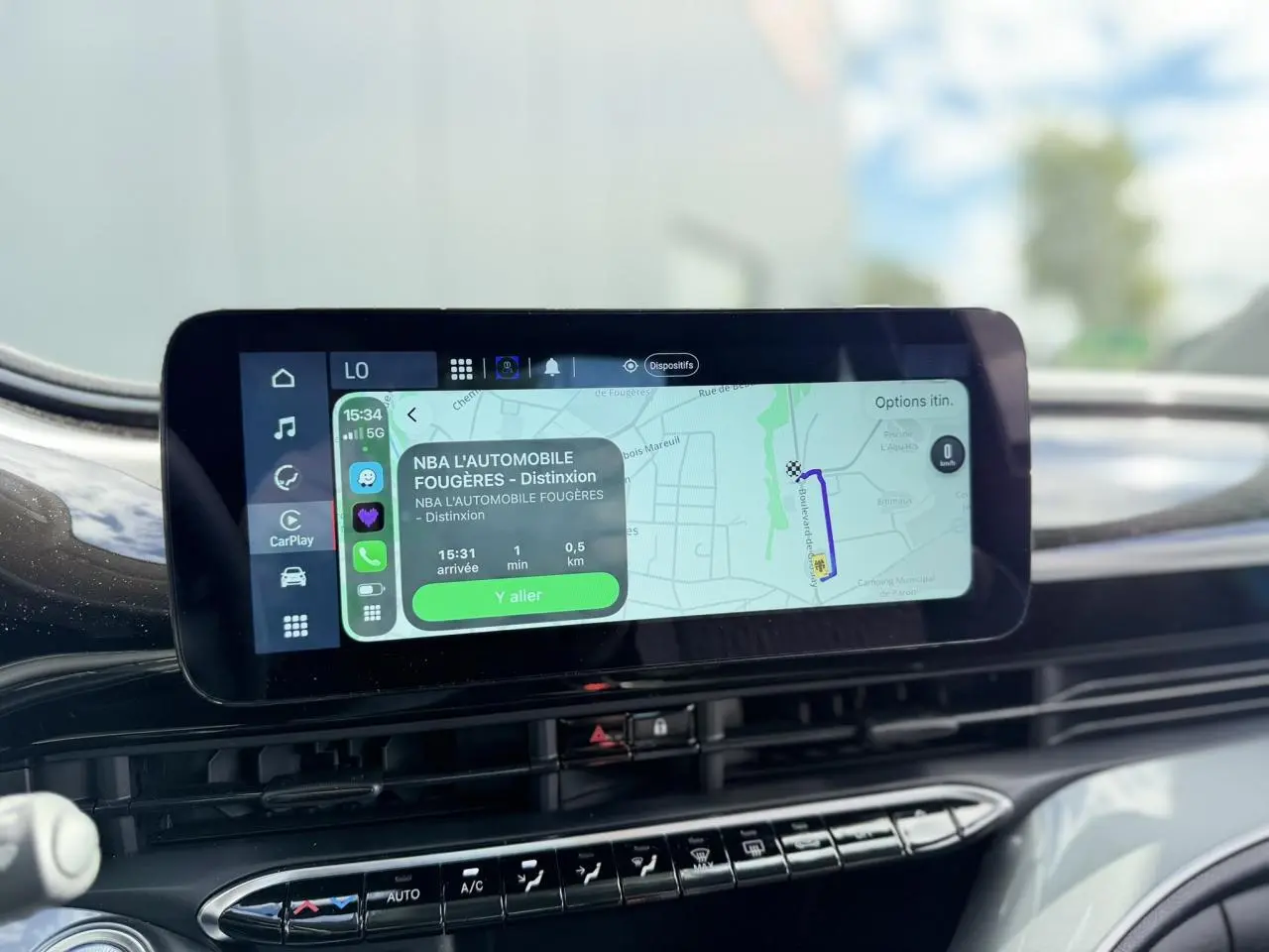Vue rapprochée de l'écran tactile central du tableau de bord de la FIAT 500 électrique blanche, affichant la navigation GPS.