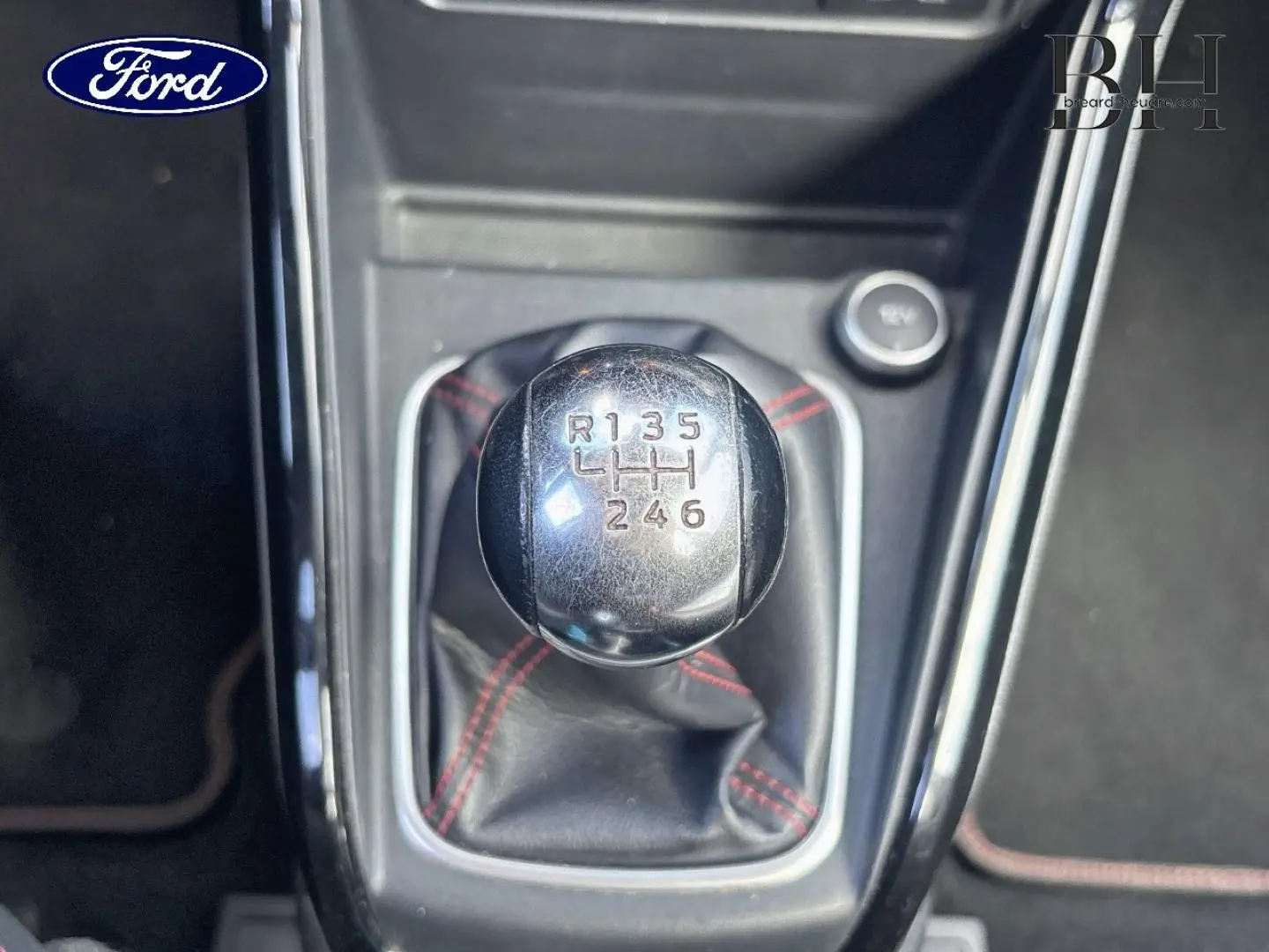 Gros plan sur le pommeau de levier de vitesses manuel noir avec surpiqûres rouges du Ford EcoSport Bleu Lightning 2018.