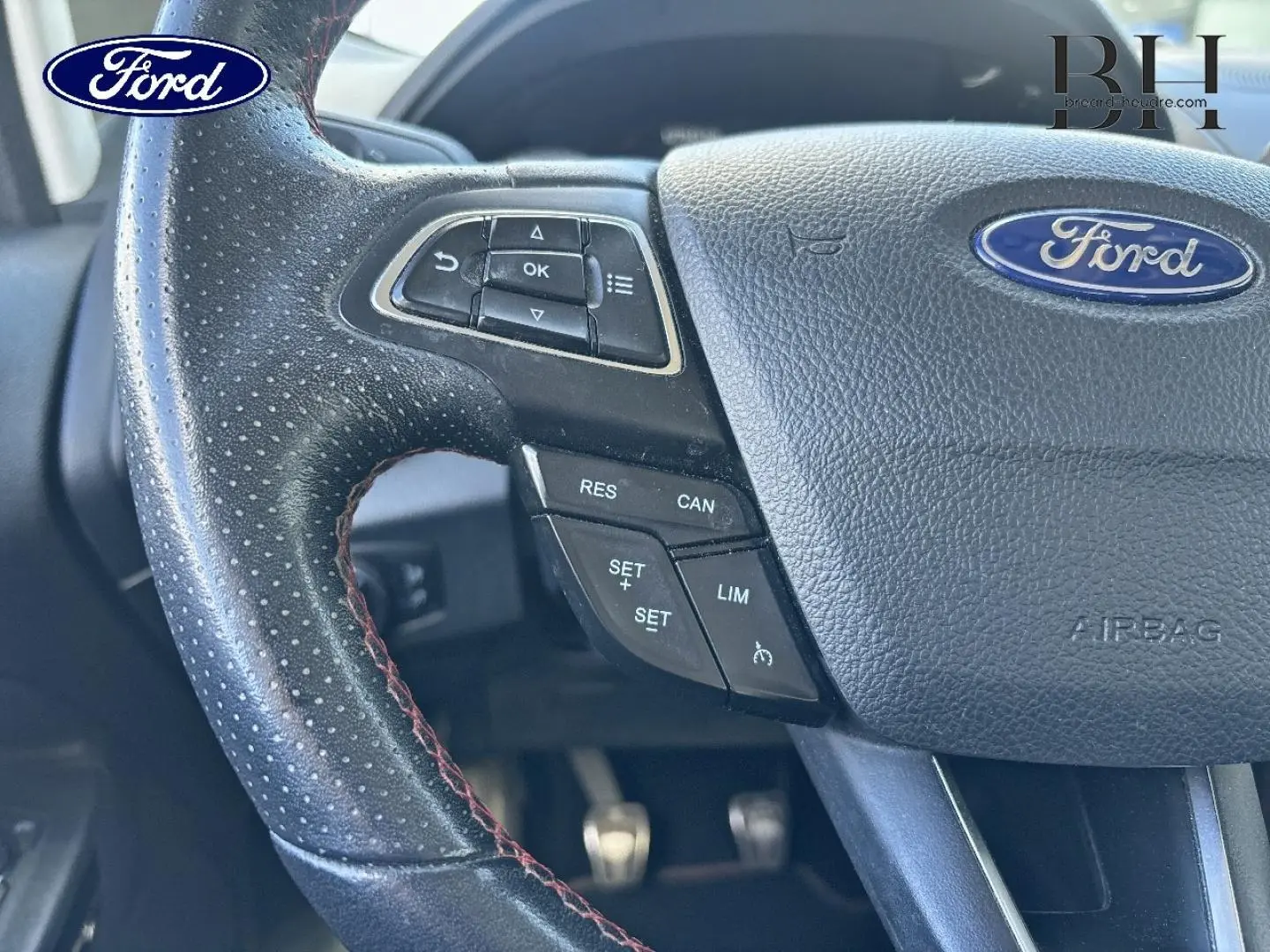 Gros plan sur le volant cuir noir perforé avec commandes multifonctions du Ford EcoSport bleu Lightning 2018.