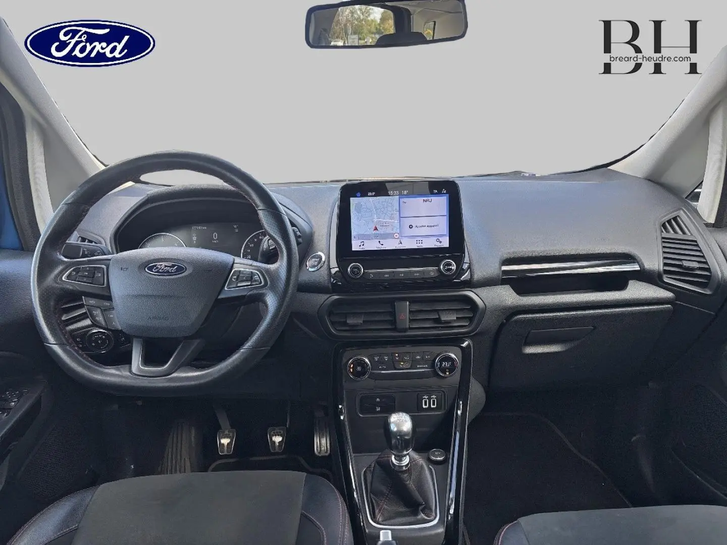 Vue intérieure avant du Ford EcoSport 2018, tableau de bord noir avec écran tactile et volant cuir multifonction.