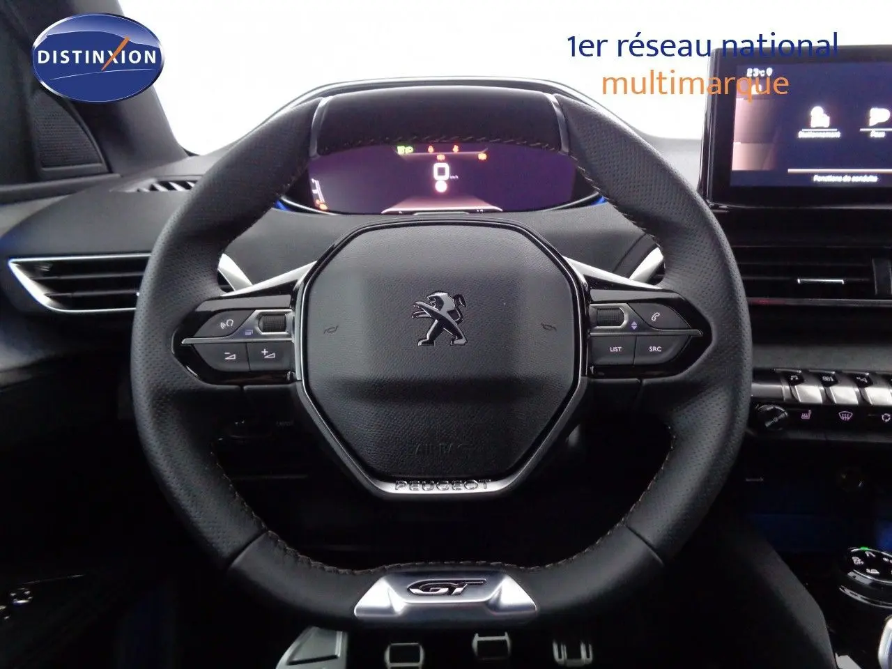 Vue rapprochée du volant cuir noir avec logo Peugeot et badge GT du Peugeot 3008 2023, tableau de bord en arrière-plan.