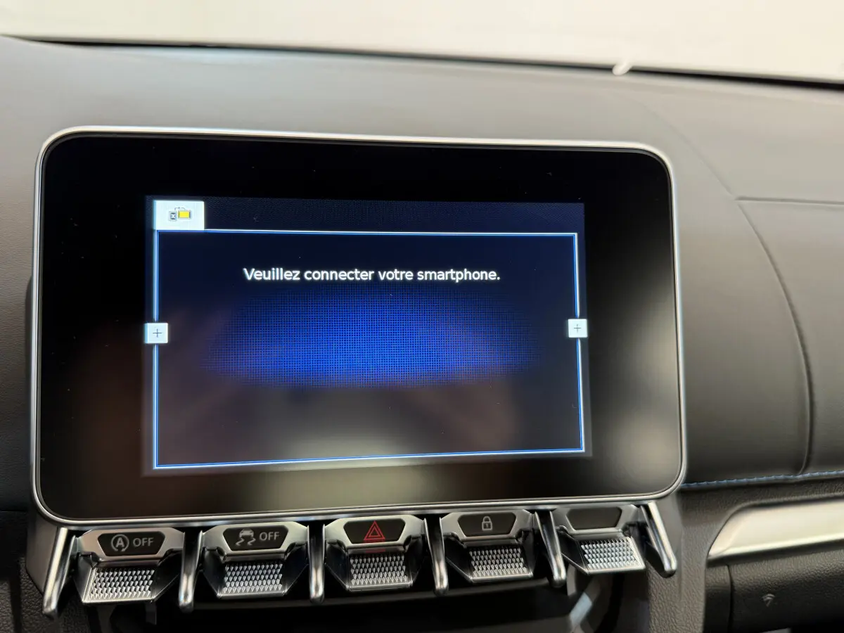 Écran tactile central affichant "Veuillez connecter votre smartphone" dans l'habitacle noir de l'Alpine A110 Legende 2019.